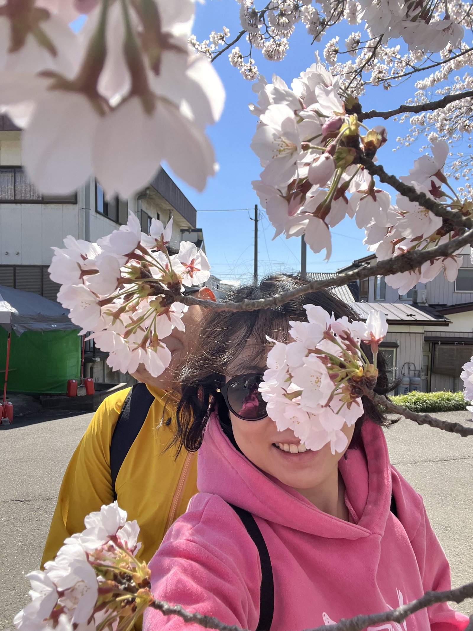 Jacob and Olivia taking a selfie behind cherry blossom branches in Miyagi