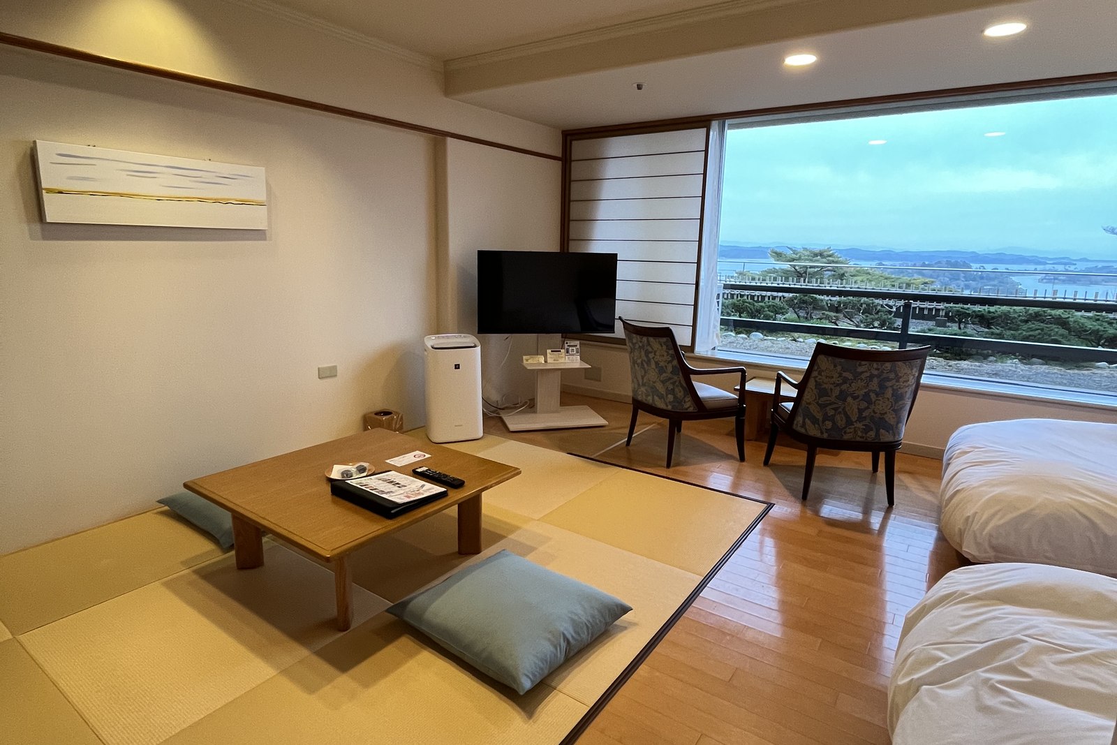 Japanese-style ryokan room with tatami mats, a low table and a bay view window